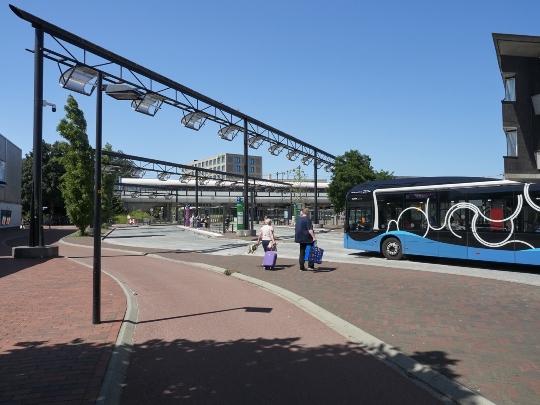 Busplein Almere Buiten met mensen en een bus
