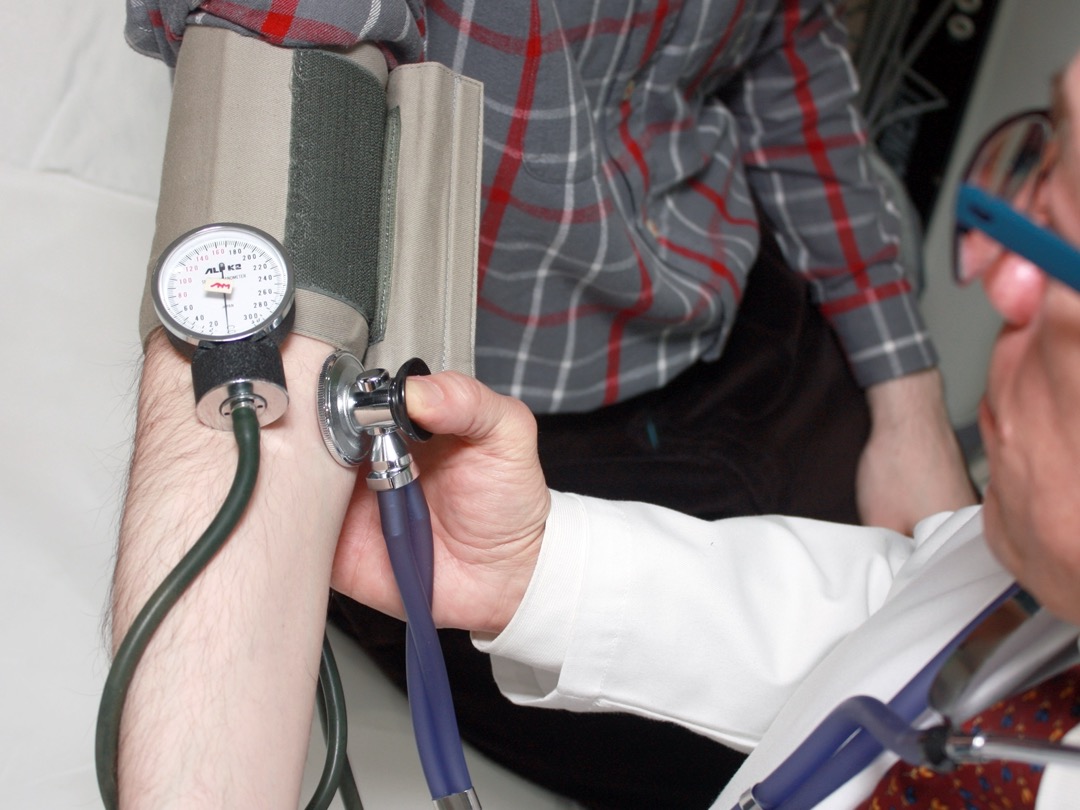 Een arts meet de bloeddruk van een patiënt