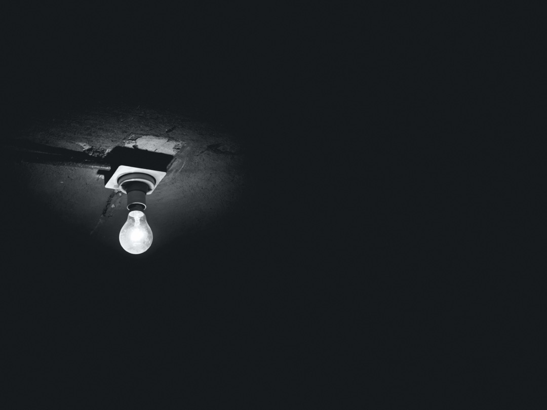 Foto van een kale peer (lamp) aan een plafond.