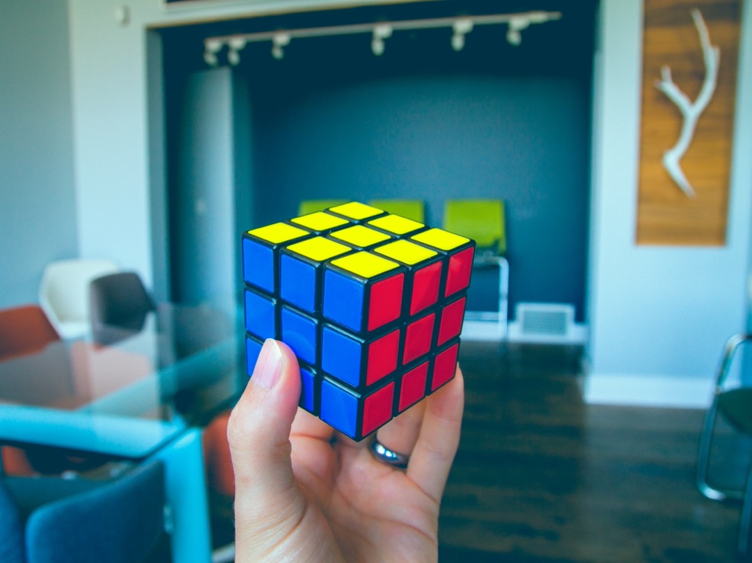 Foto van een Rubik's cube in de hand van een jongere